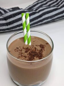 Creamy Chocolate Peanut Butter Smoothie in a glass with 2 green straws - The Simple Healthy Hub