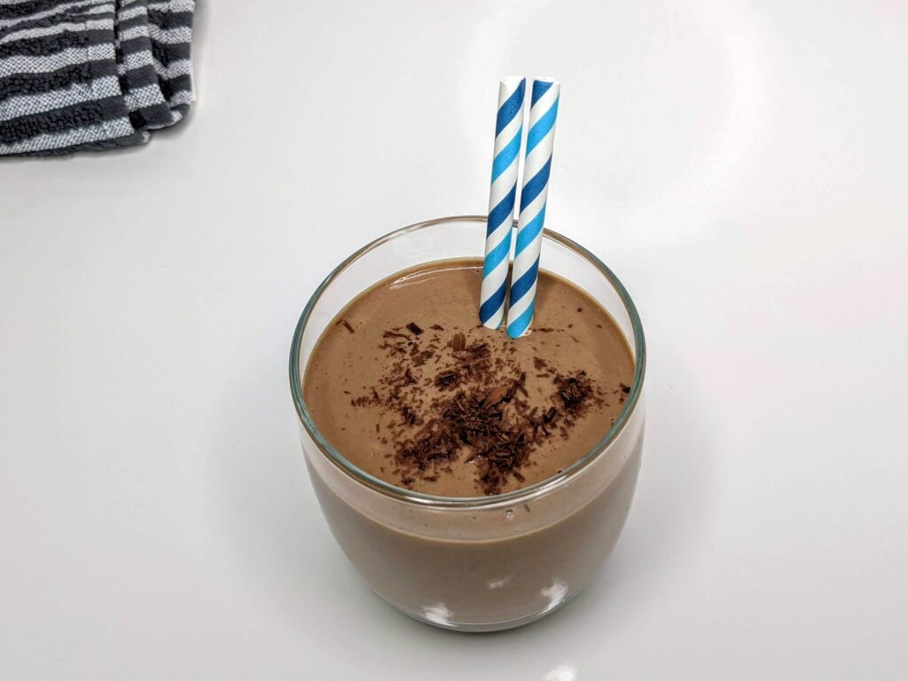 Creamy Chocolate Peanut Butter Smoothie in a glass cup with 2 blue straws - The Simple Healthy Hub