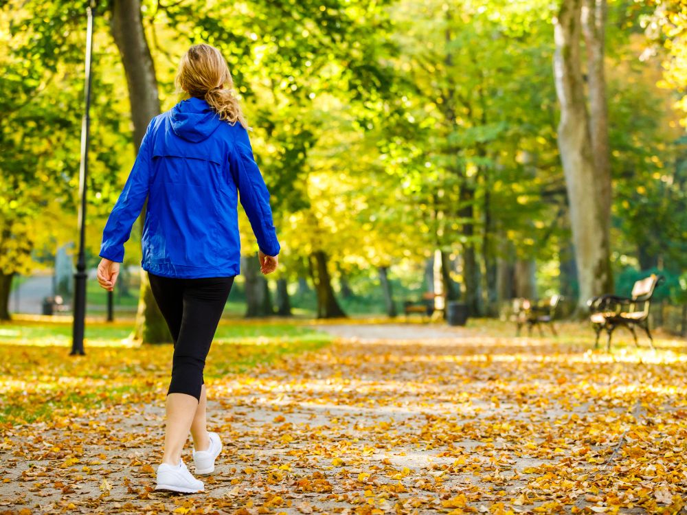 Daily Lymphatic drainage practices woman walking in park - The Simple Healthy Hub